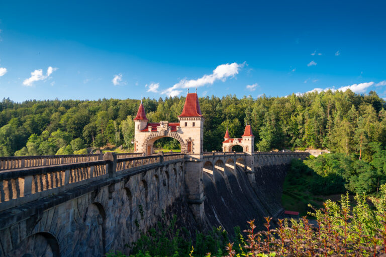 historic-stone-dam-with-red-roof-towers-in-forest-picjumbo-com
